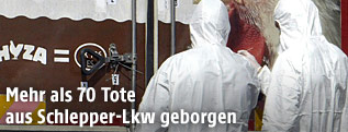 Mitarbeiter der Spurensicherung hinter dem Lkw, in dem die toten Flüchtlinge gefunden wurden