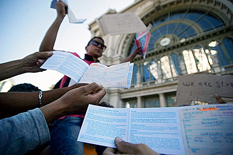 © APA/EPA/Zoltan Balogh Flüchtlinge halten gültige Tickets in der Hand