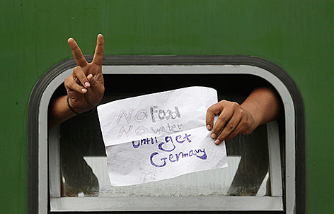 © APA/AP/Petr David Josek Ein Flüchtling hält einen Zettel aus dem Zugsfenster mit der Aufschrift "No food, no water until get Germany"