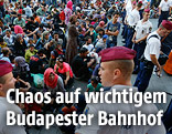 Flüchtlinge und Polizisten vor dem Bahnhof in Budapest