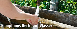 Person hält die Hände unter fließendes Wasser