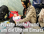 Frau sitzt mit einem Baby am Boden