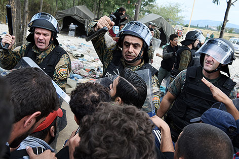 © AP/Giannis Papanikos Polizisten und Flüchtlinge an der griechisch-mazedonischen Grenze