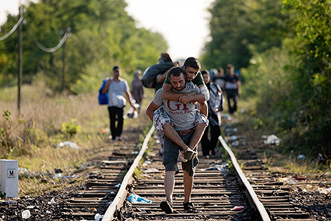 © AP/Darko Bandic Flüchtlinge gehen auf Geleise Richtung Ungarn