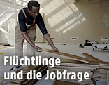 Ein Flüchtling wird in einer Holzbodenfirma angelernt