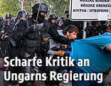 Ungarische Polizisten und Migranten
