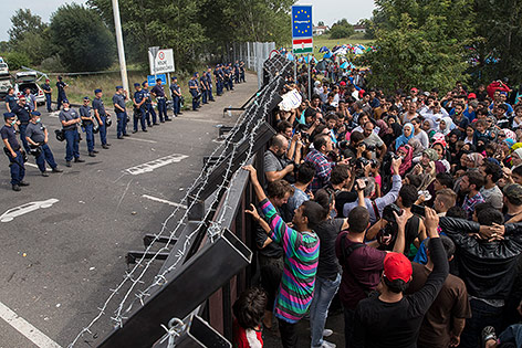 Die Grenze von Serbien zu Ungarn, Flüchtlinge und Polizisten 

