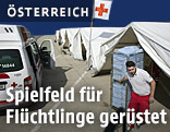 Flüchtlingshelfer in Spielfeld neben Notzelten