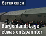 Flüchtlinge liegen vor Zelten