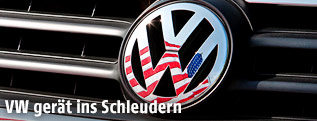 Eine US-Fahne spiegelt sich im VW-Logo
