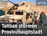 Vermummter Kämpfer neben einem gepanzerten Fahrzeug