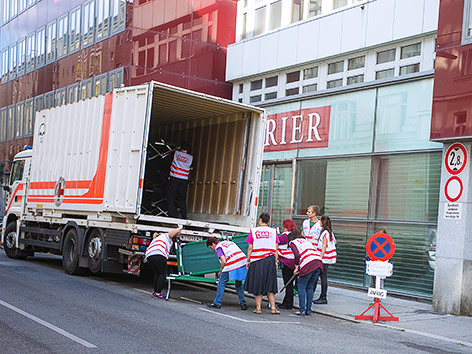 © ORF.at/Carina Kainz Helfer transportieren Betten für die ankommenden Flüchtlinge, die im ehemaligen Kurier-Gebäude untergebracht werden