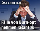 Mann greift sich an den Kopf