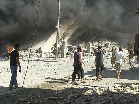 © AP/Syria Civil Defence Freiwillige Helfer vor zerbombten Häusern