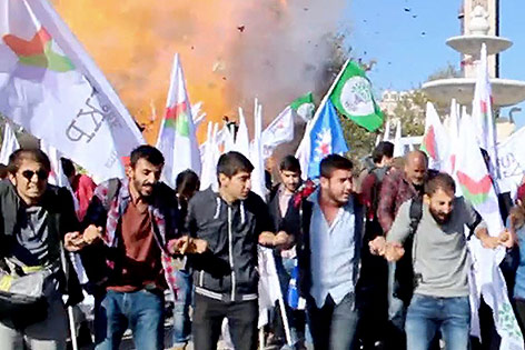 © APA/AFP/DOKUZ 8 Demonstranten in Ankara mit Explosion im Hintergrund