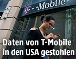 Frau mit Handy vor einem T-Mobile-Shop in New York
