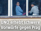 Fl&uuml;chtlinge an einem Fenster in einem Lager