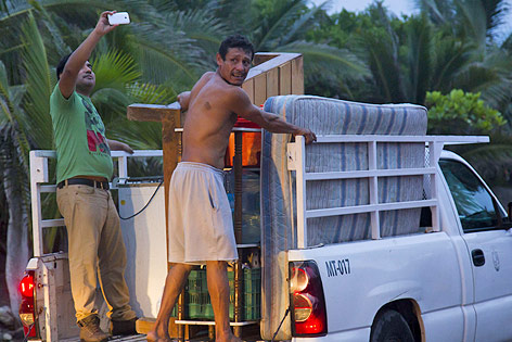 © APA/AFP/Hector Guerrero Zwei Männer packen Möbel und Haushaltsgegenstände auf einen Pick-up-Truck