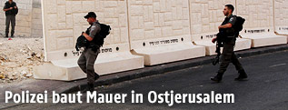 Soldaten vor einer neu errichteten Mauer