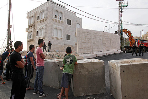 © AP/Mahmoud Illean Passanten vor einer neu errichteten Mauer