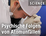 Arbeiter von Fukushima greift sich auf die Stirn