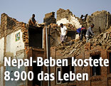M&auml;nner auf einem eingest&uuml;rzten Haus in Nepal