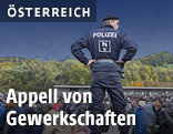 Polizist vor Flüchtlingen