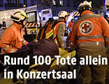 Rot-Kreuz-Mitarbeiter versorgen einen Verletzen vor der Konzerthalle in Paris