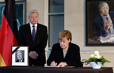 © AP/Michael Sohn Angela Merkel und Joachim Gauck tragen sich im Kondolenzbuch für den verstorbenen Ex-Kanzler Helmut Schmdt ein