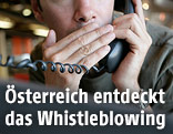 Mann flüstert ins Telefon