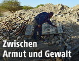 Ein Mann vor den Tr&uuml;mmern eines eingest&uuml;rzten Hauses