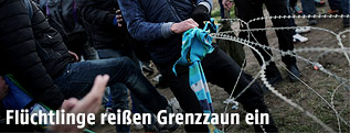 Flüchtlinge reißen den Grenzzaun in Mazedonien ein