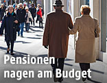 Pensionisten in der Stadt gehen auf einem Gehsteig