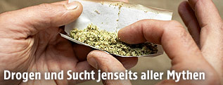 Mann rollt einen Joint