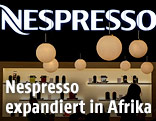 Nespresso-Logo und -Kaffeemaschinen hinter einer Theke