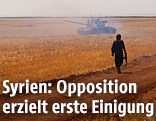 Umrisse eines bewaffneten Mannes vor einem Panzer