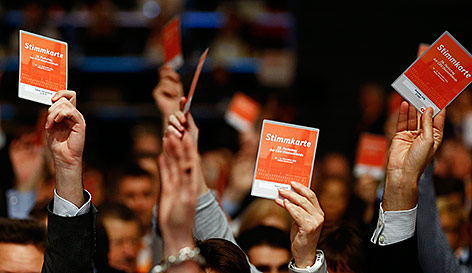 © Reuters/Kai Pfaffenbach CDU-Delegierte halten Stimmkarten in die Höhe