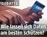 Person h&auml;lt eine Kreditkarte in der Hand und gibt Daten in einen Laptop ein