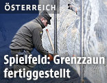 Soldat beim befestigen des Zauns