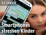 M&auml;dchen zeigt ein Smartphone