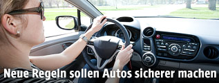 Frau sitzt hinter einem Lenkrad