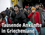 Menschen verlassen eine Fähre in Piräus