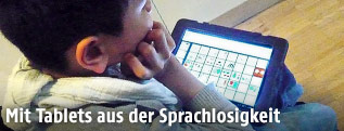 Sprachbehindertes Kind mit seinem Spezial-Tablet