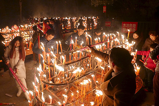 Menschen in China zünden Räucherstäbchen an