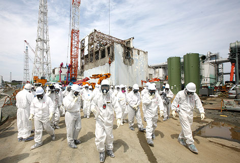 © APA/AFP/Tomohiro Ohsumi Einsatzkräfte in Spezialanzügen vor dem AKW Fukushima