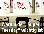Mann sitzt vor einer Wahlkabine in den USA