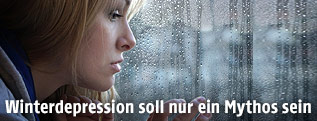 Frau sieht aus einem Fenster