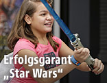Ein M&auml;dchen h&auml;lt ein Star-Wars-Lichtschwert