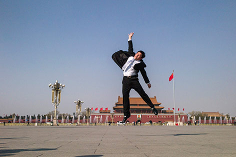 © APA/AFP/Fred Dufur Teilnehmer macht einen Luftsprung vor dem Volkskongress in China