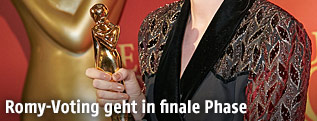 Eine Preistr&auml;gerin h&auml;lt einen Romy in der Hand